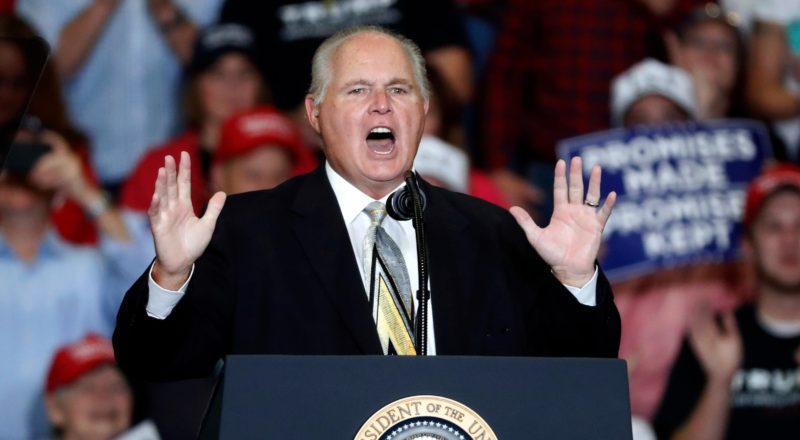 Rush Limbaugh at a podium giving a speech at a Trump campaign rally